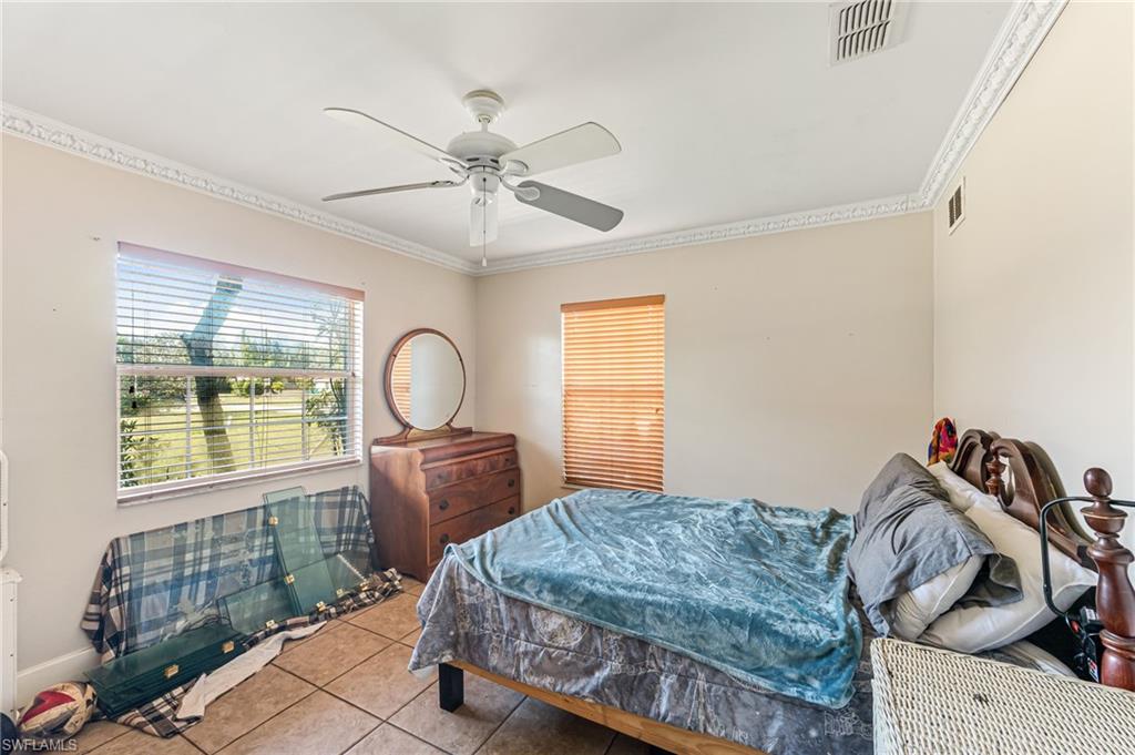 724 Pine Cone Lane Naples, FL 34104 - Photo 18 of 45 a bedroom with a bed and a window
