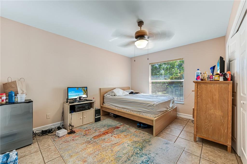 724 Pine Cone Lane Naples, FL 34104 - Photo 29 of 45 a bedroom with bed and a chandelier