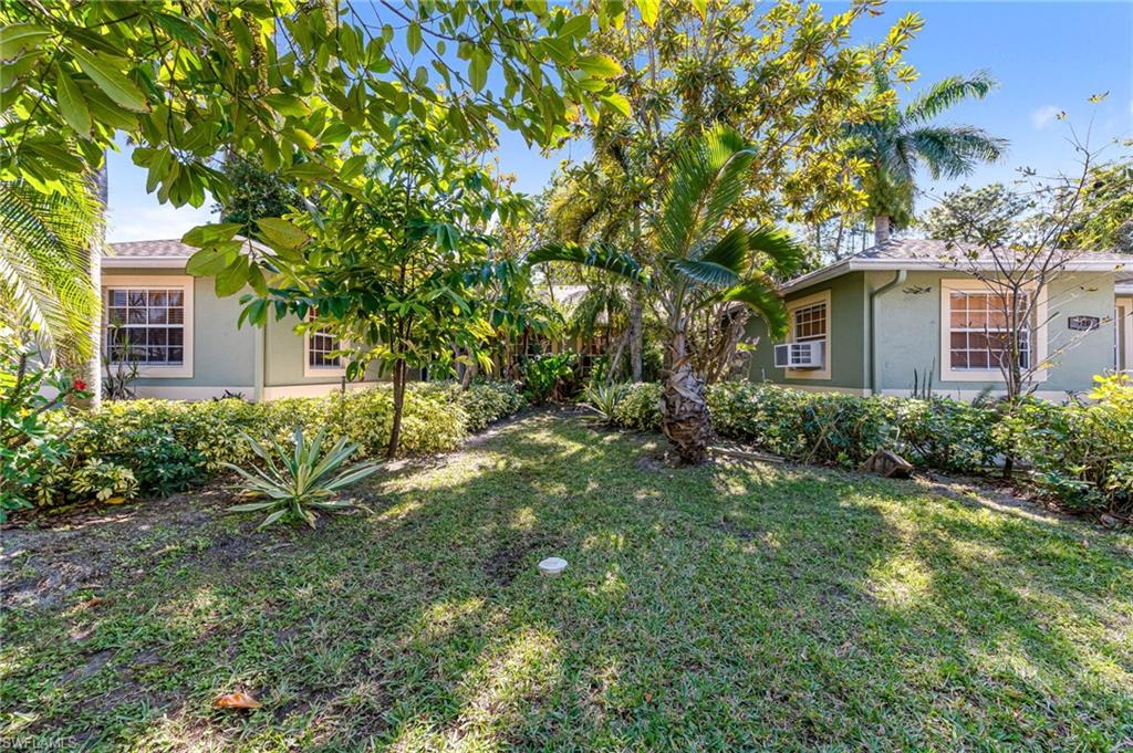 724 Pine Cone Lane Naples, FL 34104 - Photo 3 of 45 a front view of a house with a yard