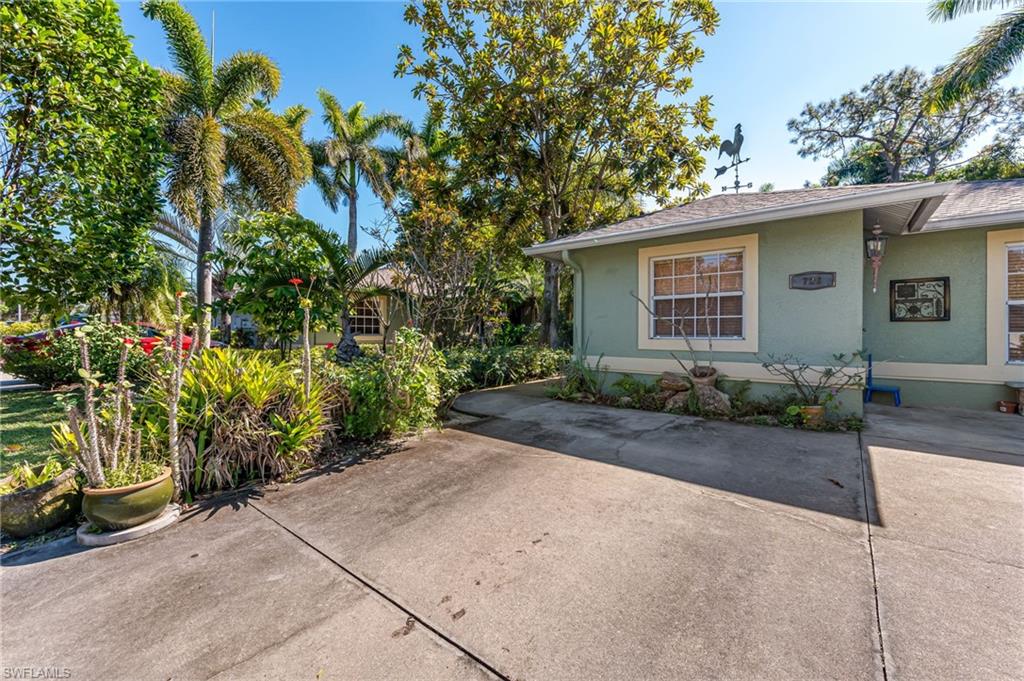 724 Pine Cone Lane Naples, FL 34104 - Photo 4 of 45 a front view of a house with garden