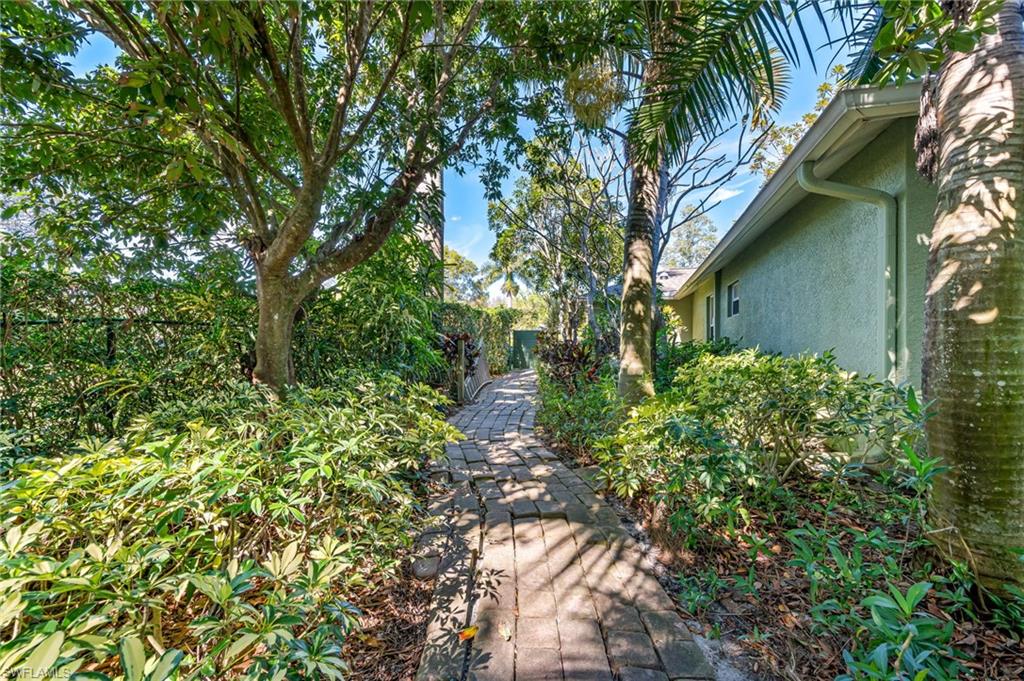 724 Pine Cone Lane Naples, FL 34104 - Photo 41 of 45 a backyard of a house with lots of green space