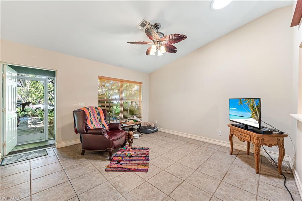 724 Pine Cone Lane Naples, FL 34104 - Photo 6 of 45 a living room with furniture a flat screen tv and a window
