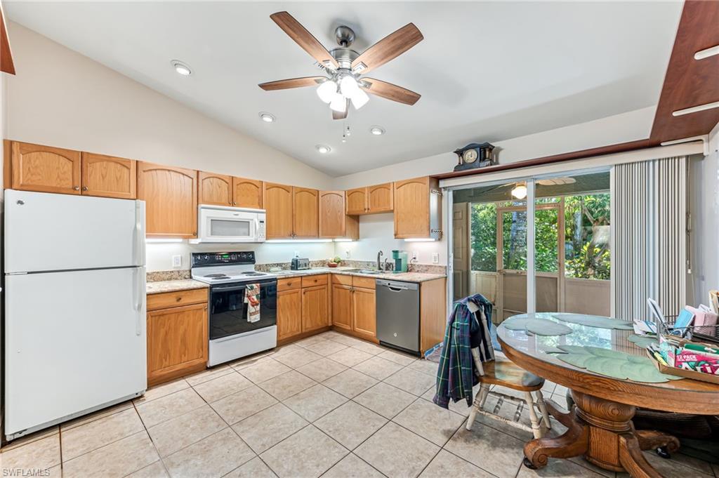 724 Pine Cone Lane Naples, FL 34104 - Photo 8 of 45 a kitchen with a table chairs stove and refrigerator