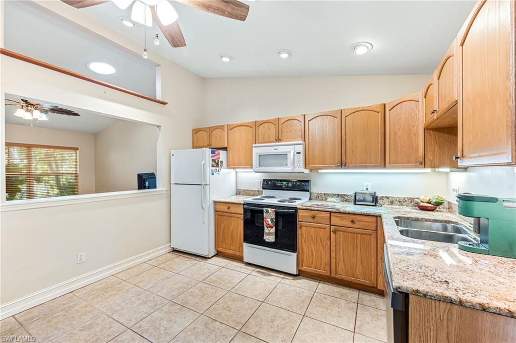 724 Pine Cone Lane Naples, FL 34104 - Photo 9 of 45 a kitchen with stainless steel appliances granite countertop a stove sink and cabinets