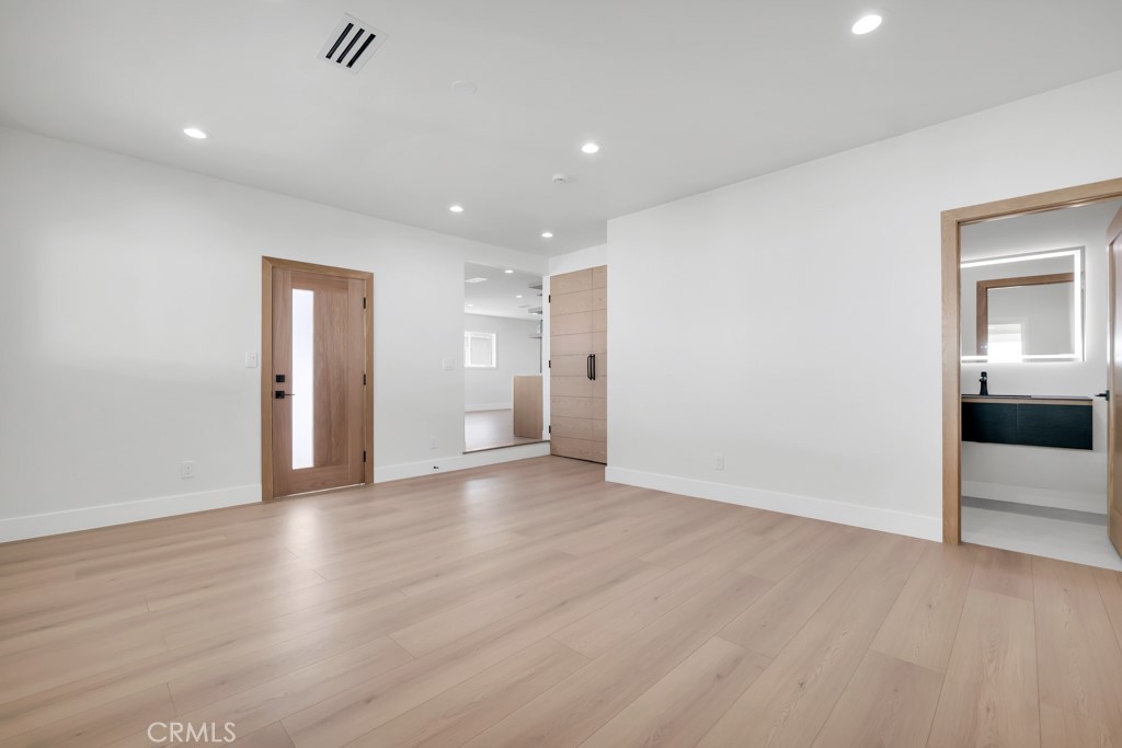 6156 Colbath Avenue Valley Glen, CA 91401 - Photo 25 of 62 a view of an empty room with wooden floor and a bathroom