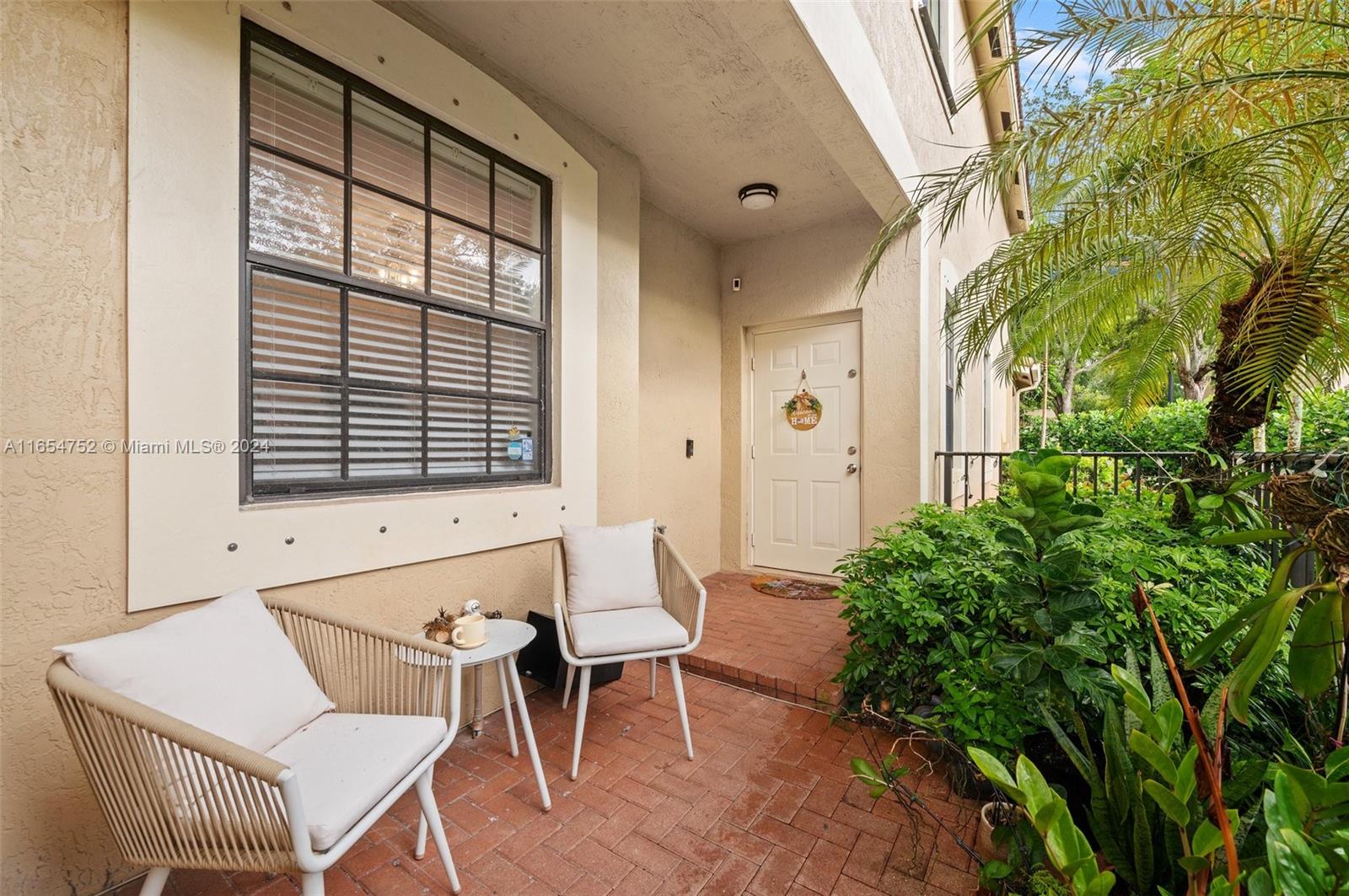 3822 Tree Top Drive Weston, FL 33332 - Photo 3 of 37 a view of a patio with table and chairs and potted plants with wooden wall