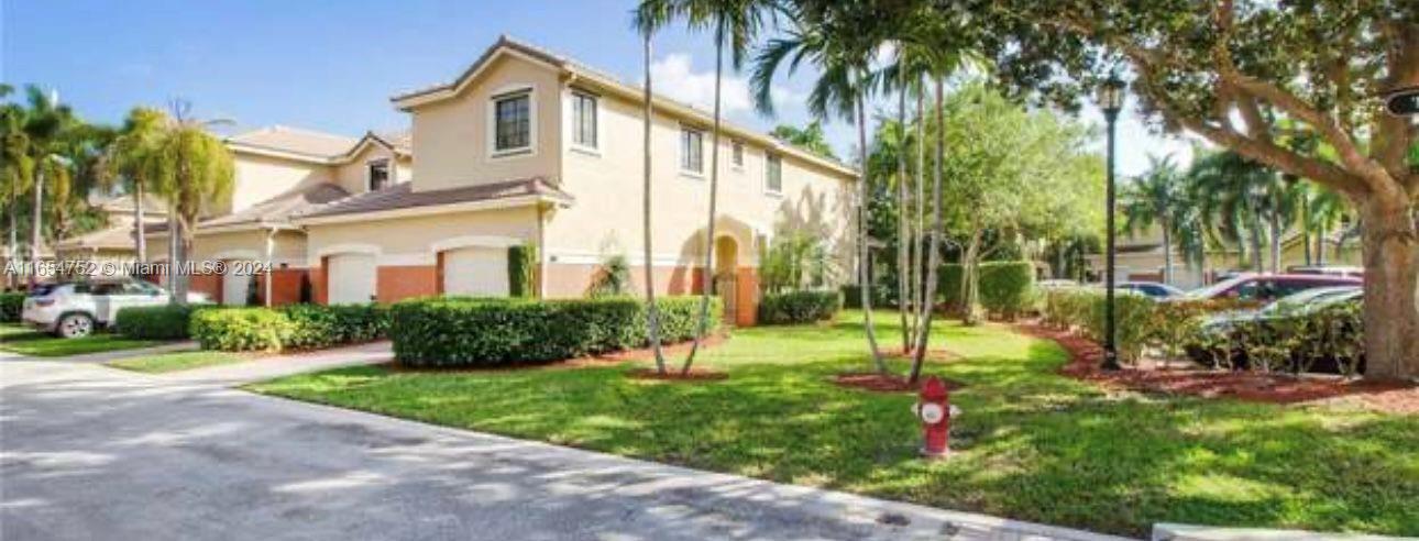 3822 Tree Top Drive Weston, FL 33332 - Photo 34 of 37 a view of a white house next to a yard with palm trees