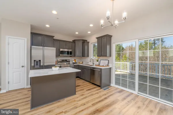 a kitchen with kitchen island granite countertop a sink cabinets and stainless steel appliances