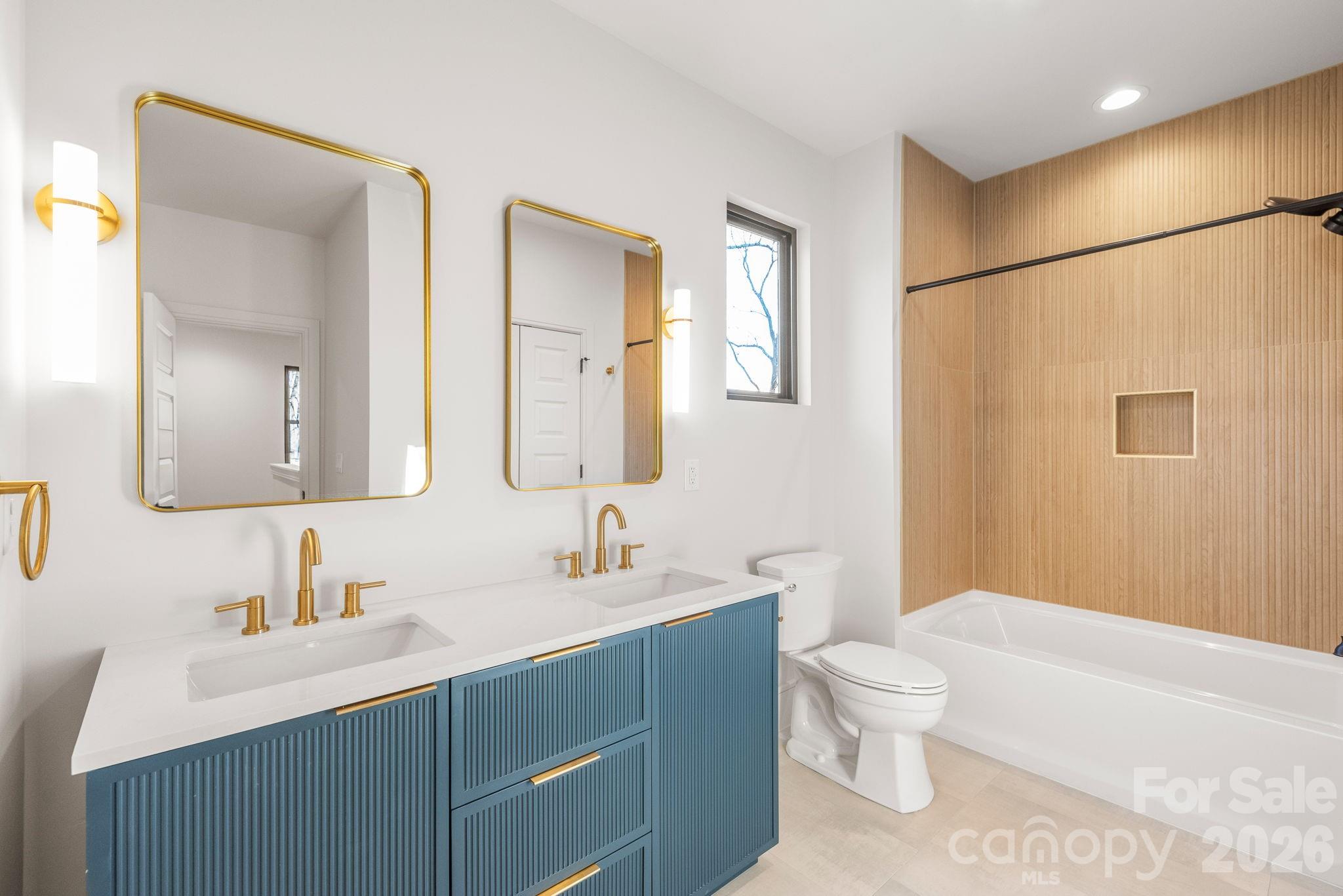 1637 Umstead Street Charlotte, NC 28205 - Photo 41 of 48 a bathroom with a toilet a sink a mirror a bathtub and vanity