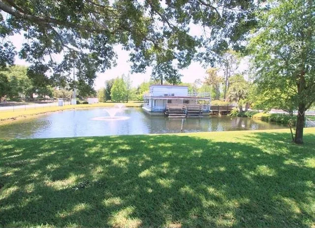 a view of swimming pool with a yard and trees