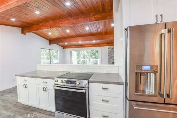 a kitchen with granite countertop white cabinets and a sink