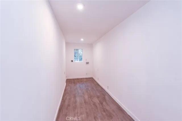 a view of a kitchen with fridge and wooden floor