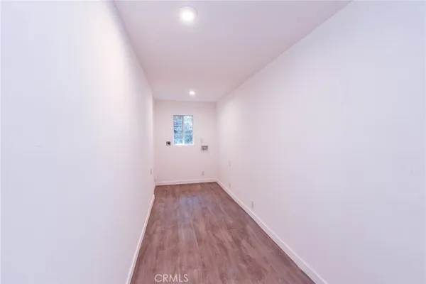 a view of a kitchen with fridge and wooden floor