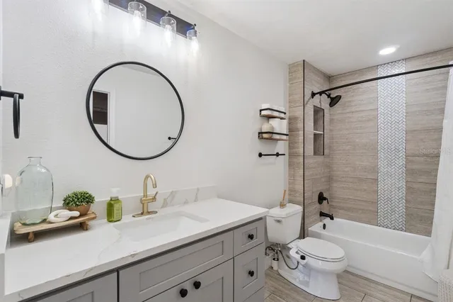 a bathroom with a granite countertop toilet a sink and a mirror