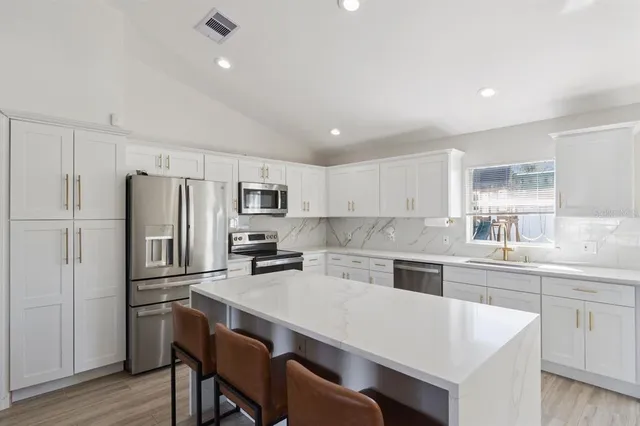 a kitchen with refrigerator cabinets and wooden floor