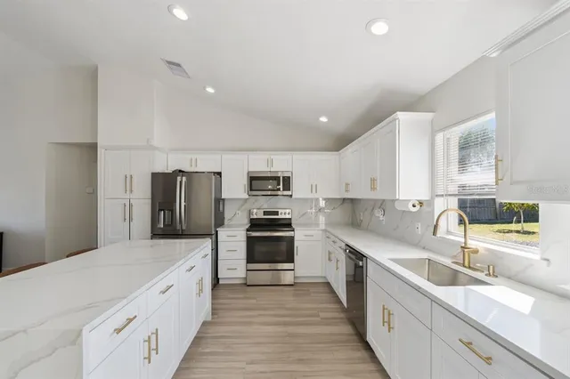 a large kitchen with a large window and stainless steel appliances