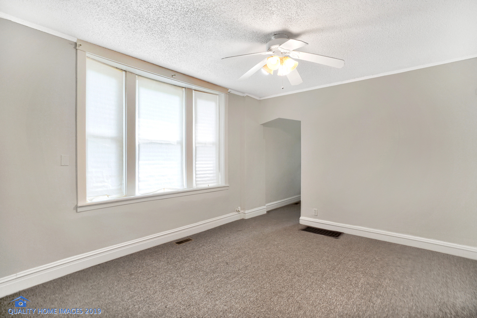 9733 South Charles Street Chicago, IL 60643 - Photo 14 of 26 an empty room with windows and chandelier fan