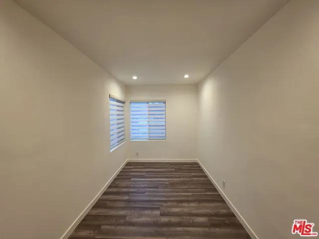 a view of empty room with window and wooden floor