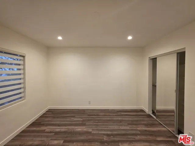 an empty room with wooden floor and closet