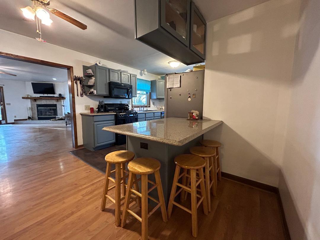 10598 North 3500W Road Manteno, IL 60950 - Photo 12 of 56 a kitchen with stainless steel appliances kitchen island granite countertop a table chairs microwave and sink