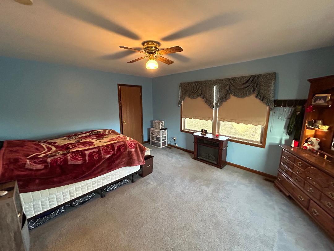 10598 North 3500W Road Manteno, IL 60950 - Photo 26 of 56 a spacious bedroom with a bed and a chandelier