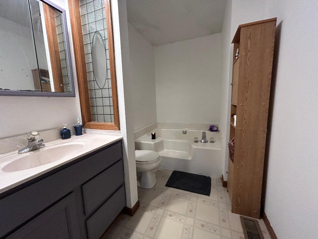 10598 North 3500W Road Manteno, IL 60950 - Photo 27 of 56 a bathroom with a double vanity sink toilet mirror and bathtub