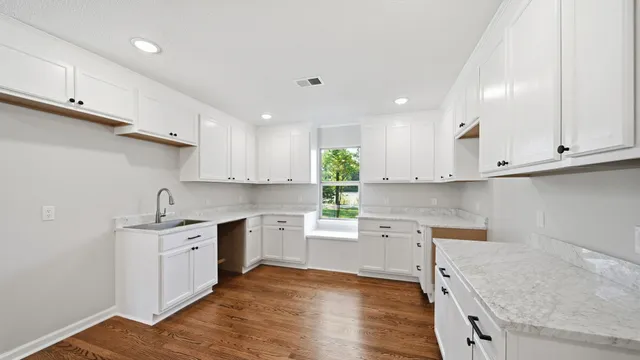 a kitchen with a sink stove top oven and cabinets