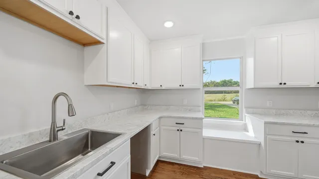 a kitchen with stainless steel appliances granite countertop a sink and a white cabinets