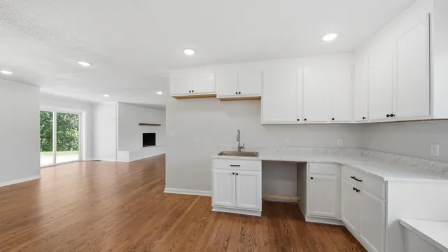 a kitchen with cabinets wooden floor and a sink