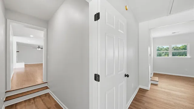 a view of a hallway with wooden floor