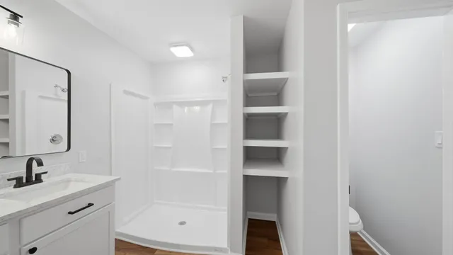 a bathroom with a shower sink and mirror