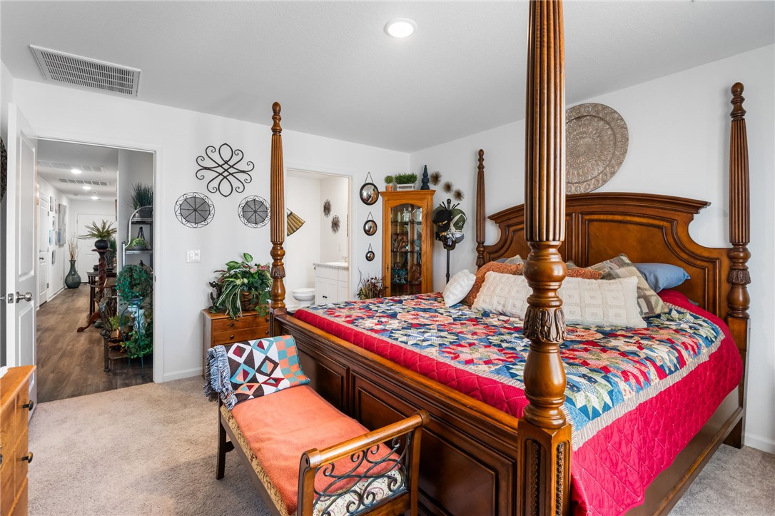 3623 East Andrea Drive Kingman, AZ 86409 - Photo 22 of 40 Bedroom featuring a four-poster bed with a carved wooden frame and carpeted flooring