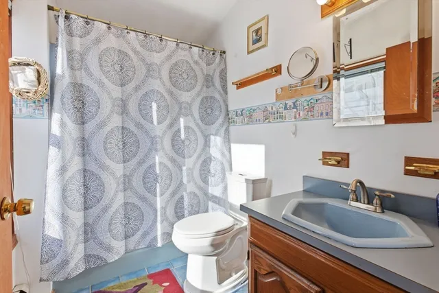 a bathroom with a granite countertop sink mirror vanity and toilet