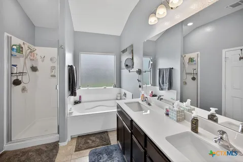 a bathroom with a sink a tub and a mirror