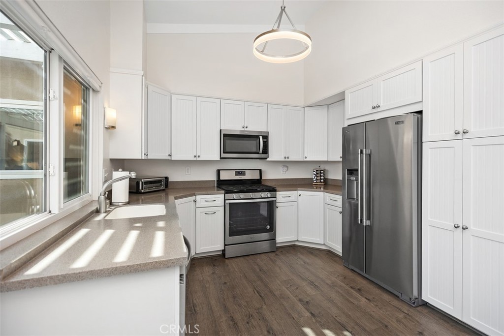 32321 Azores Road Dana Point, CA 92629 - Photo 12 of 30 a kitchen with a refrigerator a stove top oven a sink and dishwasher with wooden floor