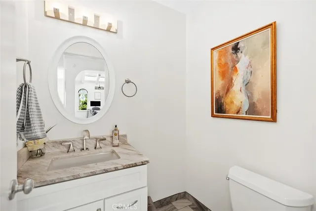 a bathroom with a granite countertop sink mirror and vanity