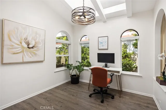 a view of a workspace with furniture and a window