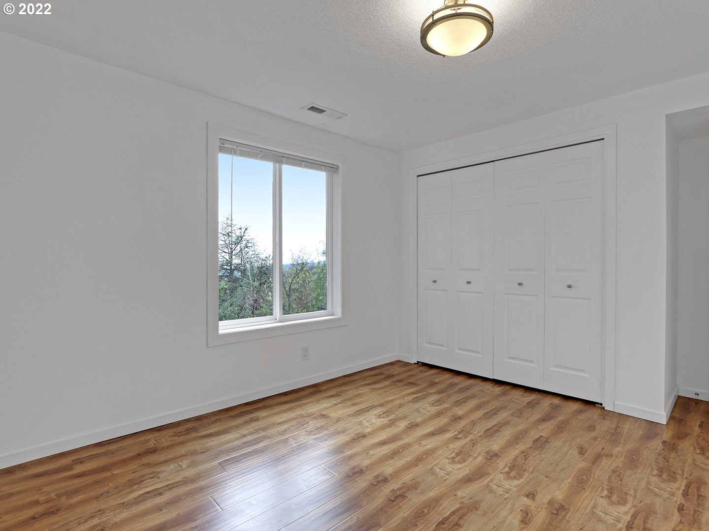 8500 Southwest Mapleridge Drive Portland, OR 97225 - Photo 22 of 30 an empty room with wooden floor and windows
