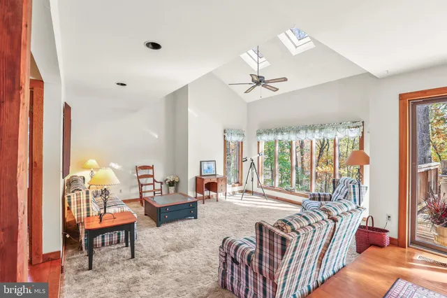 a spacious bedroom with a bed a chandelier and large window