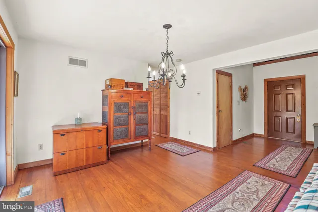 a living room with hard wood floors and a chandelier