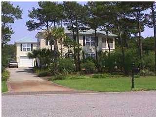 a front view of a house with a garden and tree