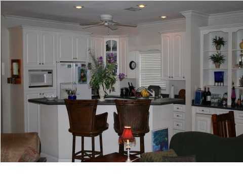 132 Emerald Ridge Santa Rosa Beach, FL 32459 - Photo 8 of 15 a living room with stainless steel appliances kitchen island granite countertop a table chairs and a refrigerator