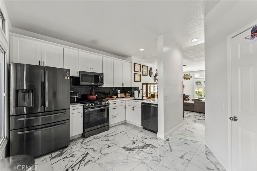 23653 Lexington Court, Unit 2 Laguna Niguel, CA 92677 - Photo 11 of 30 a kitchen with granite countertop a refrigerator and a sink