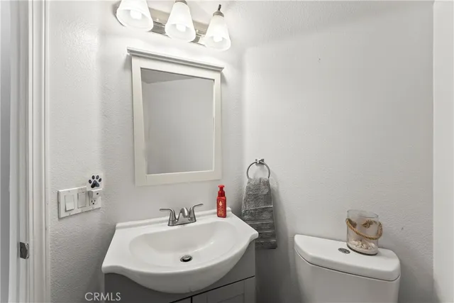 a bathroom with a sink a toilet and mirror