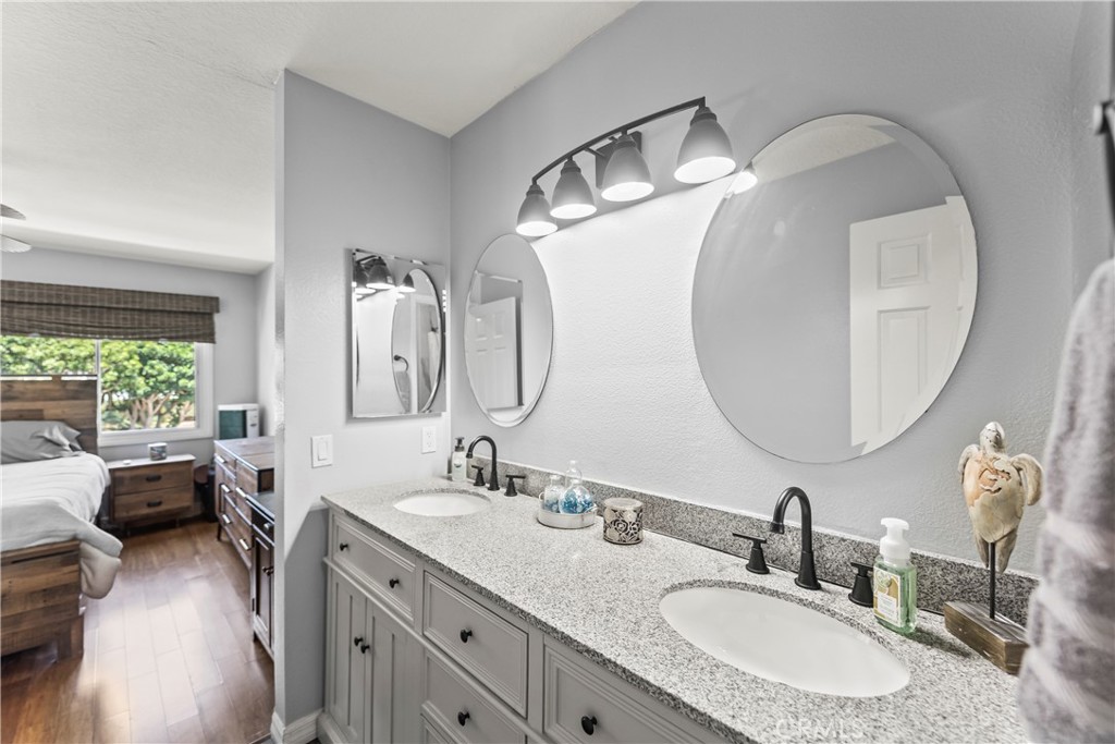 23653 Lexington Court, Unit 2 Laguna Niguel, CA 92677 - Photo 18 of 30 a en suite bathroom with a double vanity sink and a mirror