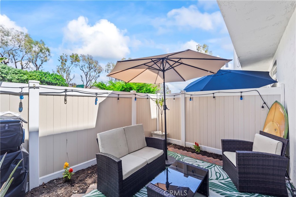 23653 Lexington Court, Unit 2 Laguna Niguel, CA 92677 - Photo 26 of 30 a view of a patio with a table and chairs under an umbrella