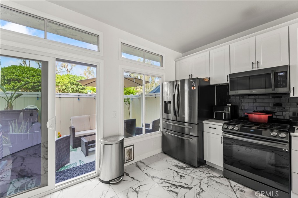 23653 Lexington Court, Unit 2 Laguna Niguel, CA 92677 - Photo 9 of 30 a kitchen with stainless steel appliances a stove a refrigerator and a microwave