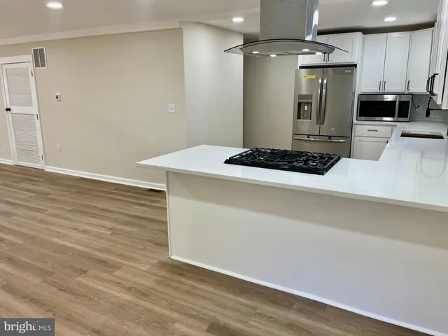 a kitchen with a wooden floor and a refrigerator