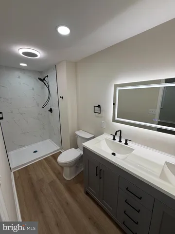 a bathroom with a double vanity sink toilet and shower