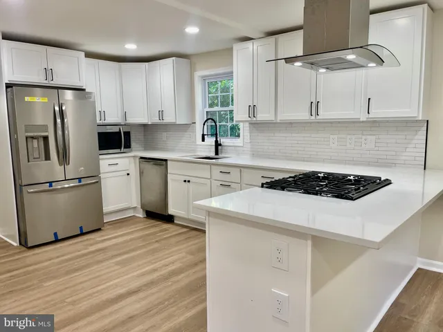 a kitchen with a white stove top oven and refrigerator